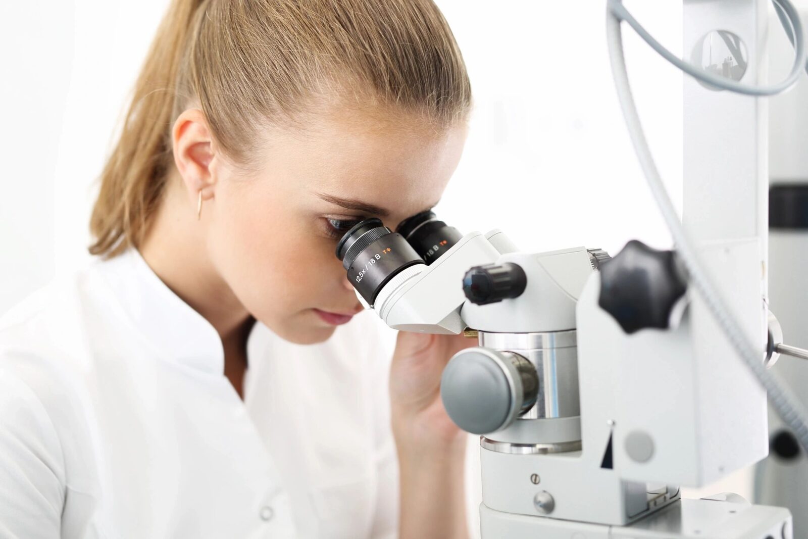 A woman looking through a microscope at something